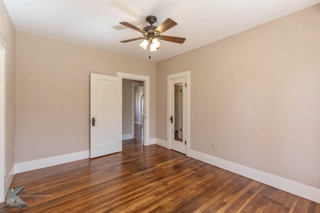 unfurnished room featuring baseboards, wood finished floors, and a ceiling fan