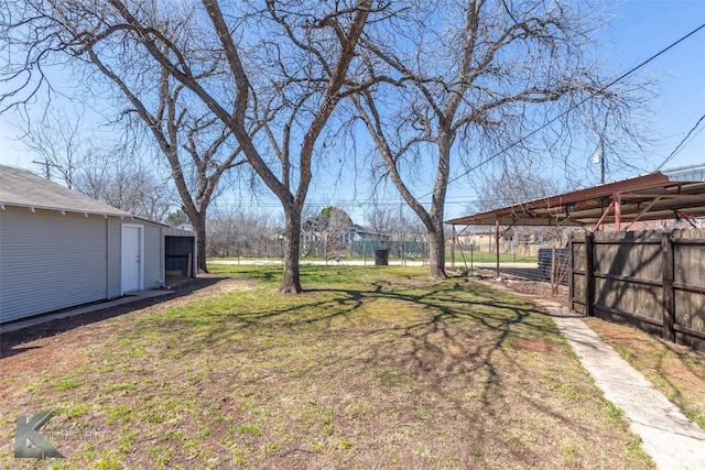 view of yard featuring an outbuilding and fence