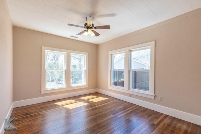 empty room featuring baseboards, wood-type flooring, visible vents, and a ceiling fan