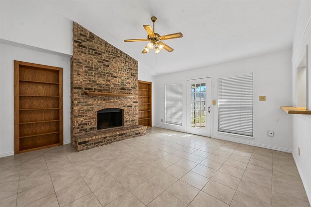 unfurnished living room with tile patterned floors, built in features, a brick fireplace, ceiling fan, and vaulted ceiling