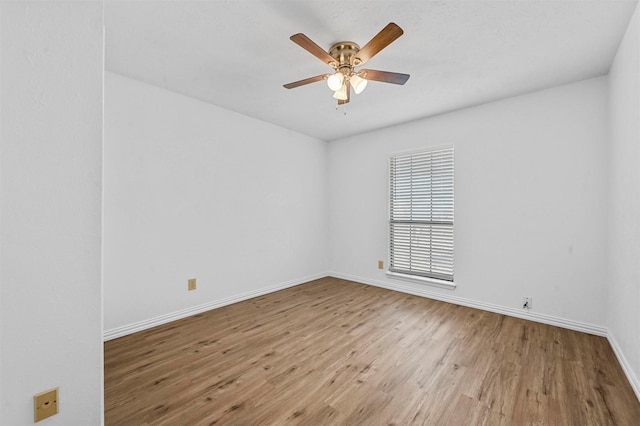 unfurnished room featuring a ceiling fan, wood finished floors, and baseboards