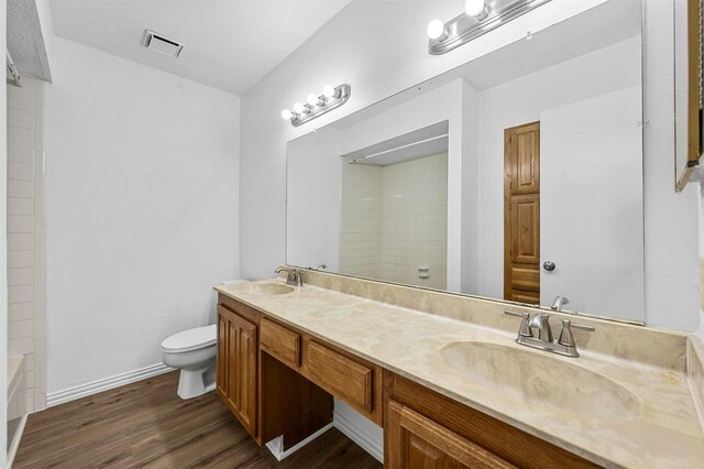 full bathroom featuring visible vents, toilet, wood finished floors, and a sink