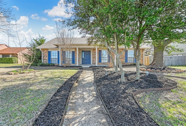 single story home with a front lawn, fence, and brick siding