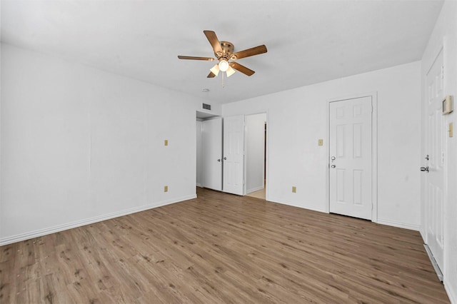 unfurnished bedroom featuring visible vents, baseboards, wood finished floors, and a ceiling fan