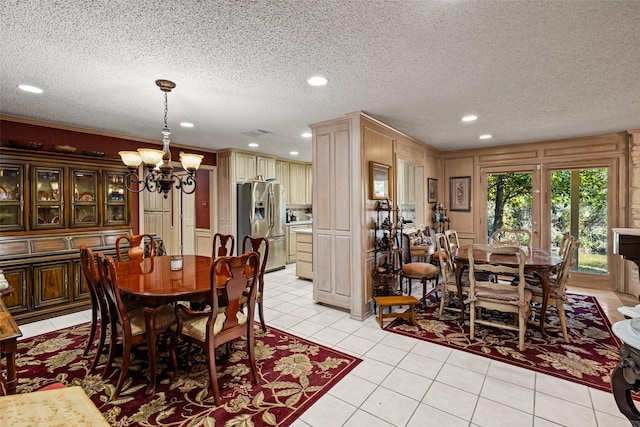 dining area with a textured ceiling, an inviting chandelier, and light tile patterned flooring