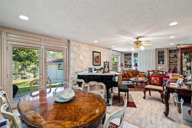 dining area featuring crown molding, ceiling fan, built in features, wood finished floors, and a textured ceiling