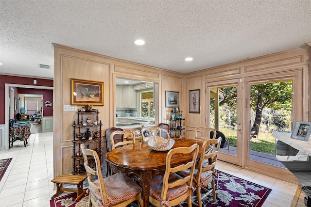 dining area featuring a wealth of natural light, visible vents, light tile patterned flooring, and a decorative wall