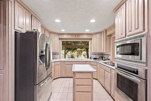 kitchen featuring light brown cabinets, light countertops, light tile patterned floors, recessed lighting, and stainless steel appliances