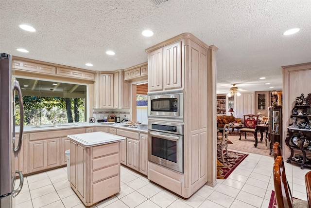 kitchen with light countertops, light tile patterned floors, appliances with stainless steel finishes, and light brown cabinetry