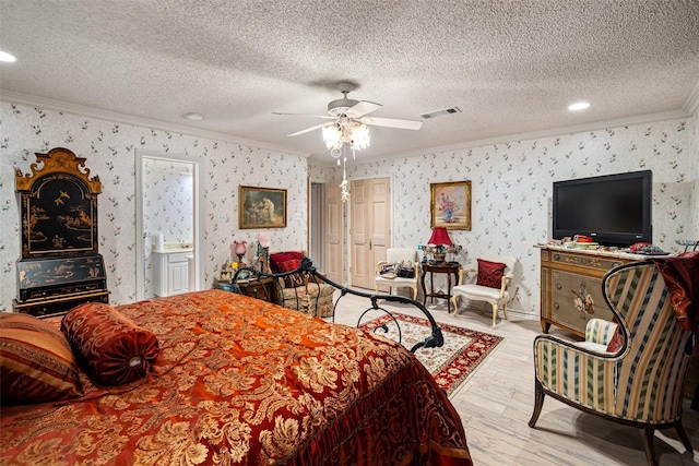 bedroom with wallpapered walls, crown molding, visible vents, and a textured ceiling