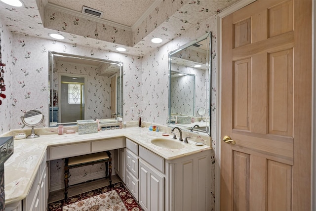 bathroom with visible vents, a textured ceiling, wallpapered walls, and vanity