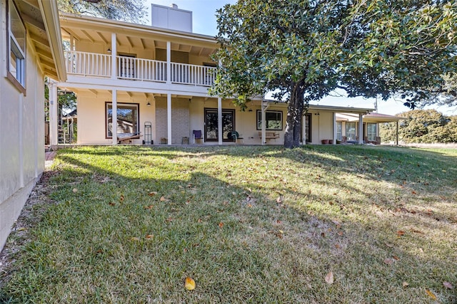 view of front of home with brick siding, a chimney, a balcony, and a front lawn