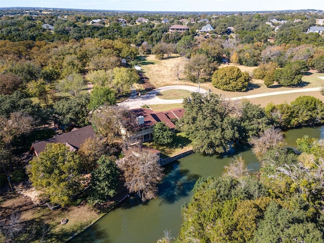 drone / aerial view with a forest view and a water view