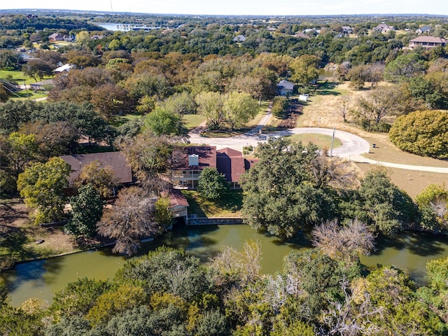 drone / aerial view featuring a wooded view and a water view