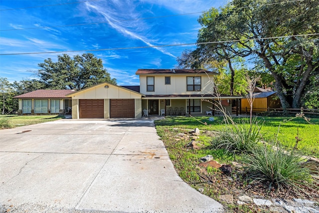 view of front of property featuring covered porch, an attached garage, driveway, and a front yard