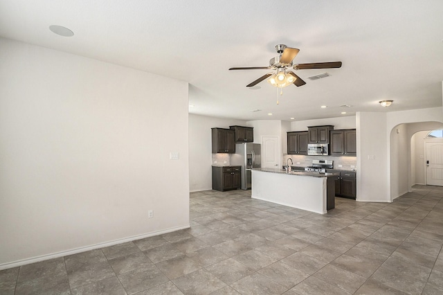 kitchen featuring visible vents, backsplash, stainless steel appliances, arched walkways, and ceiling fan