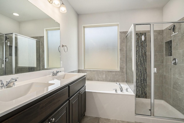 full bathroom with a sink, a garden tub, a stall shower, and double vanity