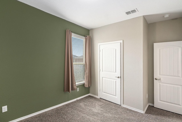 unfurnished bedroom with visible vents, baseboards, and carpet