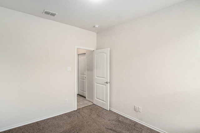 unfurnished room featuring carpet flooring, baseboards, and visible vents