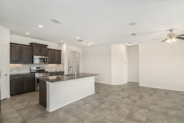 kitchen featuring arched walkways, visible vents, backsplash, and stainless steel appliances