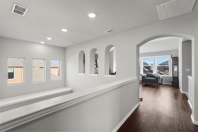 corridor with dark wood finished floors, recessed lighting, baseboards, and visible vents