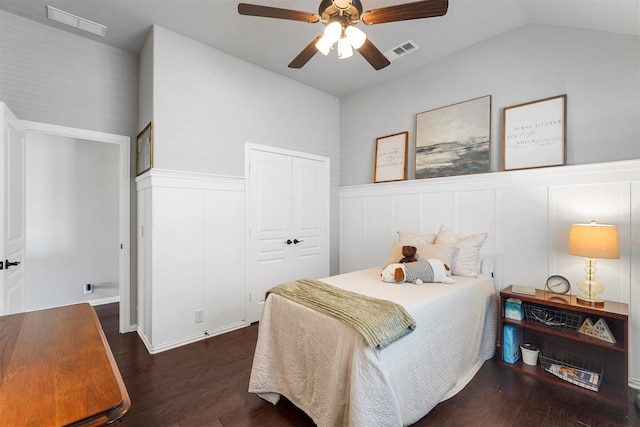 bedroom with a wainscoted wall, wood finished floors, and visible vents