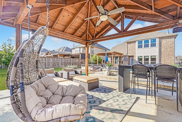 view of patio / terrace with fence, a gazebo, an outdoor hangout area, outdoor dining space, and a ceiling fan