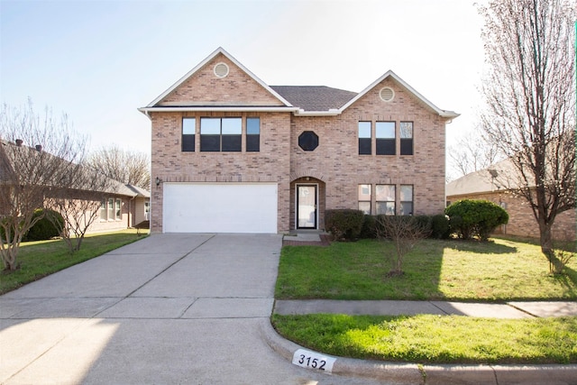 traditional home featuring a front yard, concrete driveway, brick siding, and an attached garage