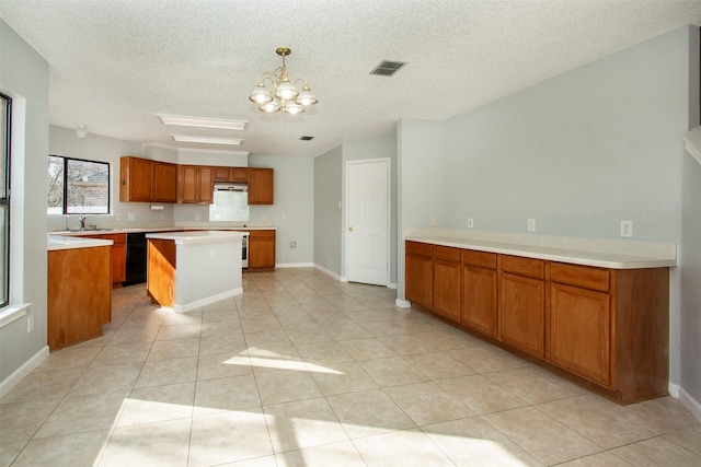 kitchen featuring visible vents, a kitchen island, light countertops, black dishwasher, and brown cabinetry