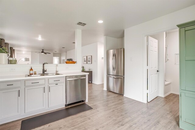 kitchen featuring a sink, stainless steel appliances, and light wood-style flooring