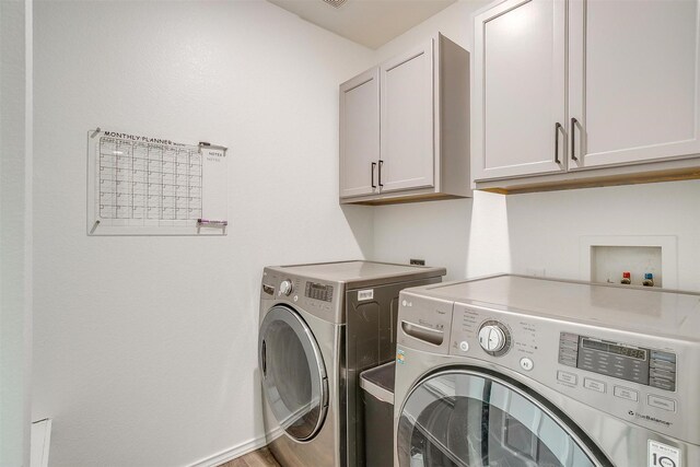 washroom featuring washer and dryer and cabinet space