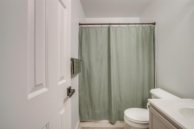 bathroom featuring vanity, toilet, and a shower with curtain