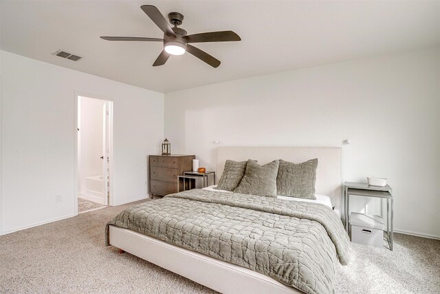 carpeted bedroom featuring baseboards, a ceiling fan, visible vents, and connected bathroom