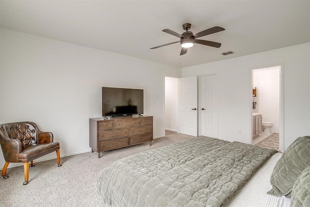 bedroom featuring visible vents, baseboards, ceiling fan, light colored carpet, and ensuite bathroom