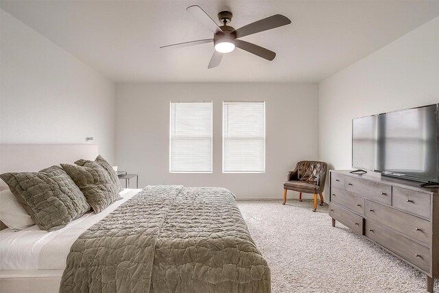 bedroom with a ceiling fan, baseboards, and light carpet