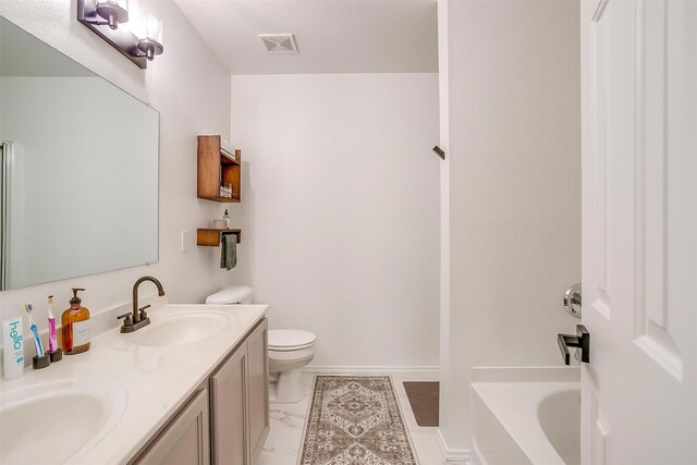 bathroom featuring visible vents, toilet, a sink, double vanity, and a bathtub