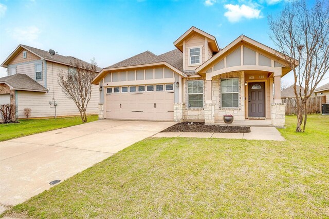 view of front of home with an attached garage, a shingled roof, a front yard, stone siding, and driveway