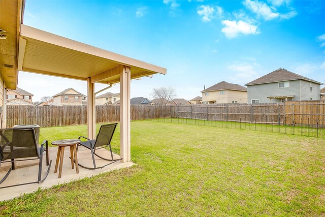 view of yard featuring a patio area, a residential view, and a fenced backyard