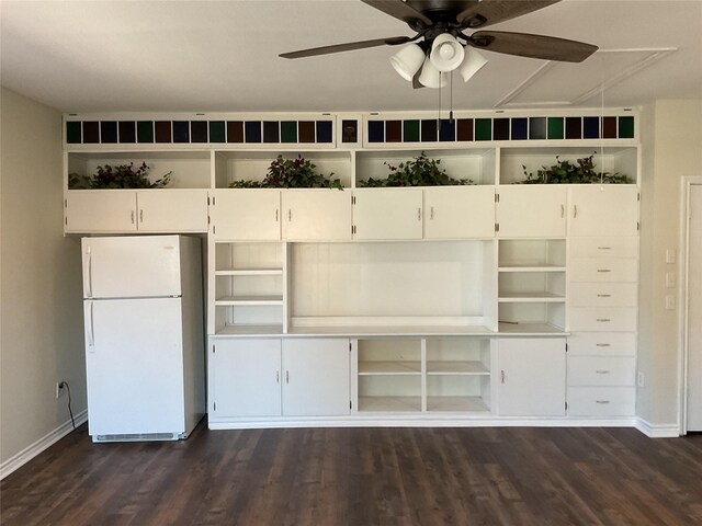 unfurnished bedroom featuring ceiling fan, baseboards, dark wood-style floors, and freestanding refrigerator