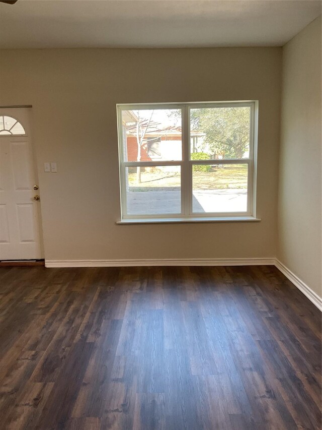 interior space featuring baseboards and dark wood-type flooring