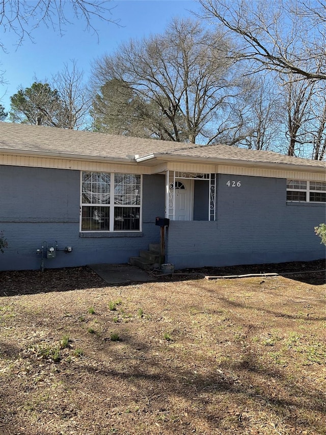 view of front of property with brick siding and a shingled roof