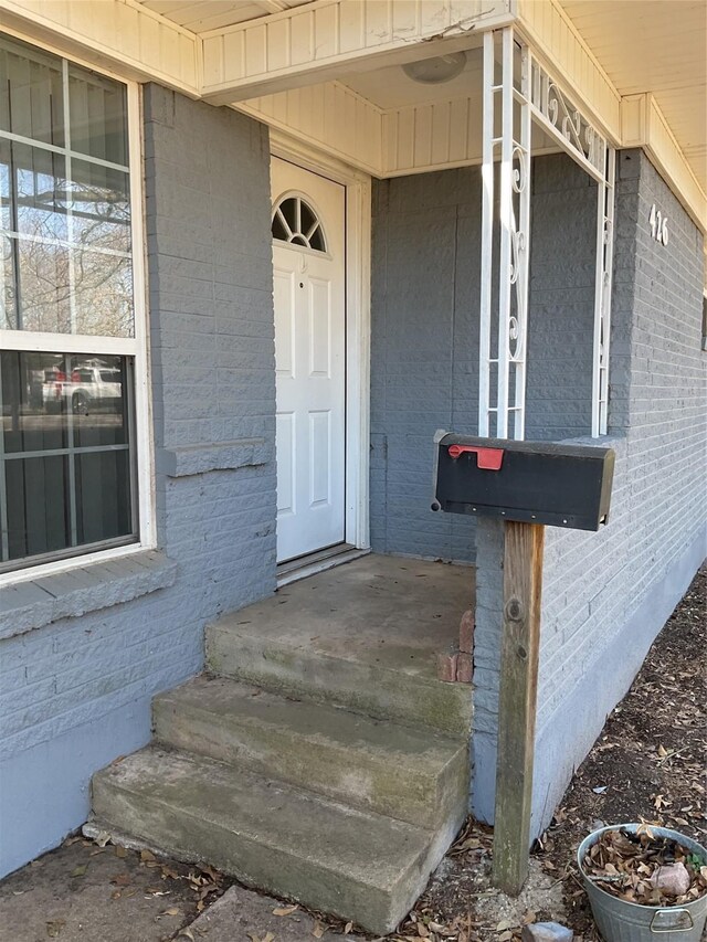 property entrance featuring brick siding