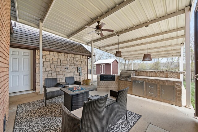 view of patio / terrace featuring an outbuilding, a shed, exterior kitchen, ceiling fan, and a grill