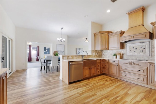 kitchen featuring dishwasher, light countertops, custom range hood, and a sink