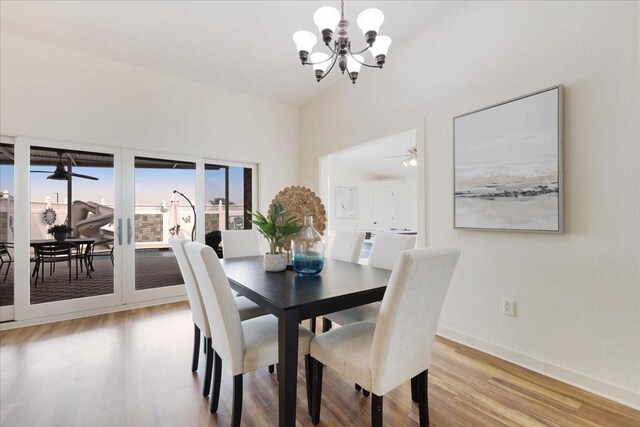 dining space featuring ceiling fan with notable chandelier, light wood-style floors, and baseboards