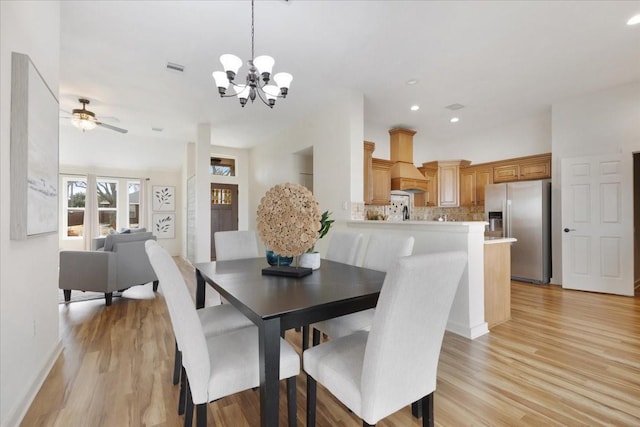 dining space featuring visible vents, baseboards, light wood-type flooring, recessed lighting, and ceiling fan with notable chandelier