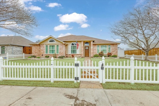 view of front of home with brick siding, a fenced front yard, and a front yard