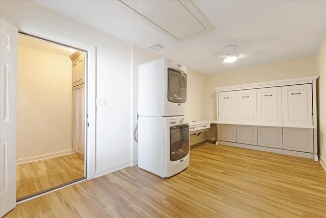 laundry area with stacked washing maching and dryer, light wood finished floors, baseboards, attic access, and laundry area