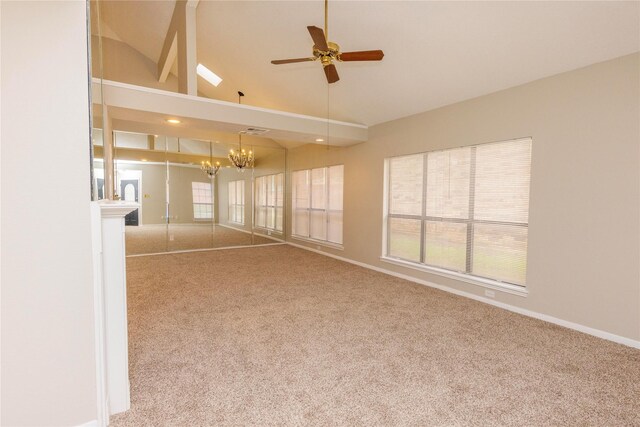 carpeted empty room with baseboards, a healthy amount of sunlight, ceiling fan with notable chandelier, and lofted ceiling