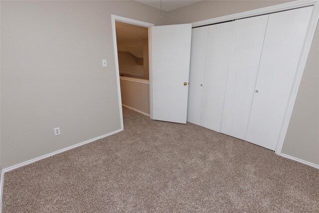 unfurnished bedroom featuring carpet flooring and a closet